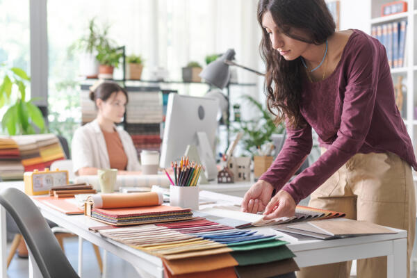 Polster- und Dekorationsnäherin wählt passende Stoffe aus Polster- und Dekorationsnäherin wählt passende Stoffe aus