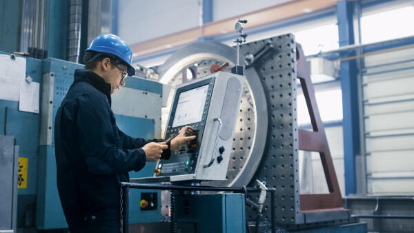 Metallbildner bedient CNC-Maschine Metallbildner bedient CNC-Maschine