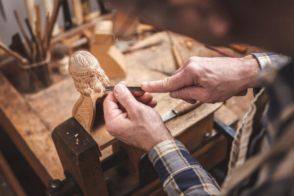 Holzbildhauer schnitzt eine Holzfigur