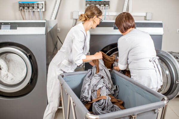 Hauswirtschaftshelferinnen erledigen die Wäsche einer Einrichtung Hauswirtschaftshelferinnen erledigen die Wäsche einer Einrichtung