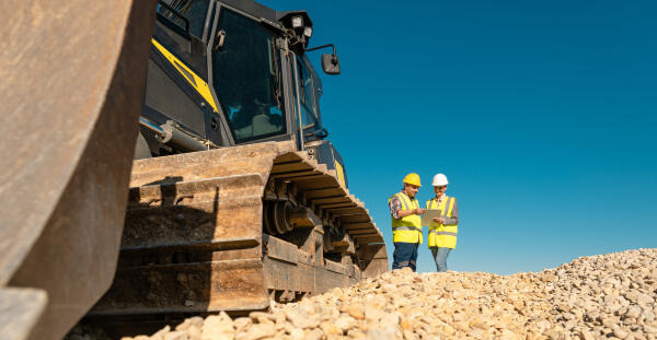 Aufbereitungsmechaniker vor Baumaschine Aufbereitungsmechaniker vor Baumaschine