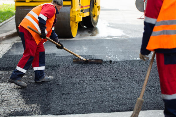 Straßenbauer glätten Asphalt