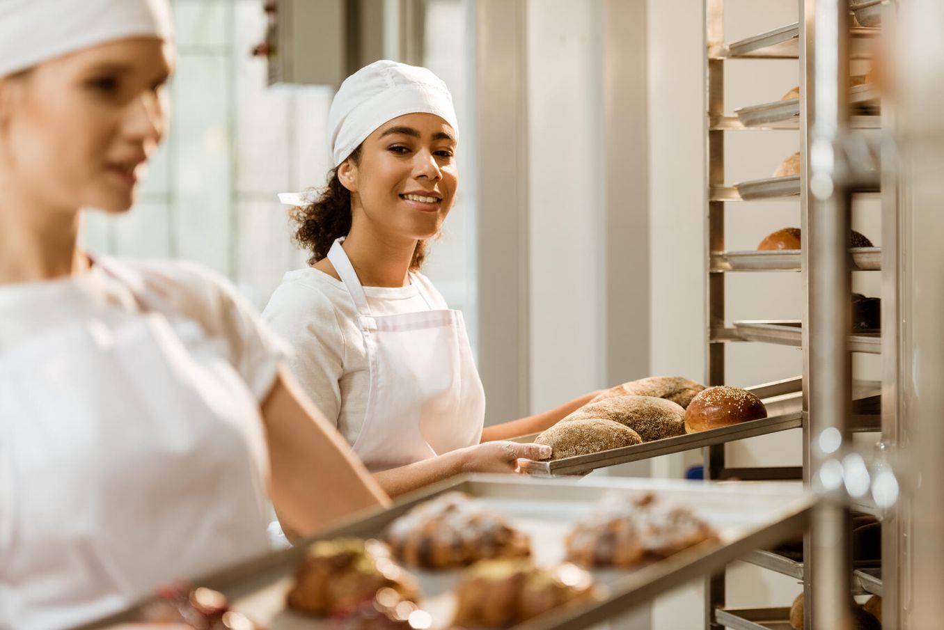 Bäckerinnen bringen Gebäck zum Verkaufsraum