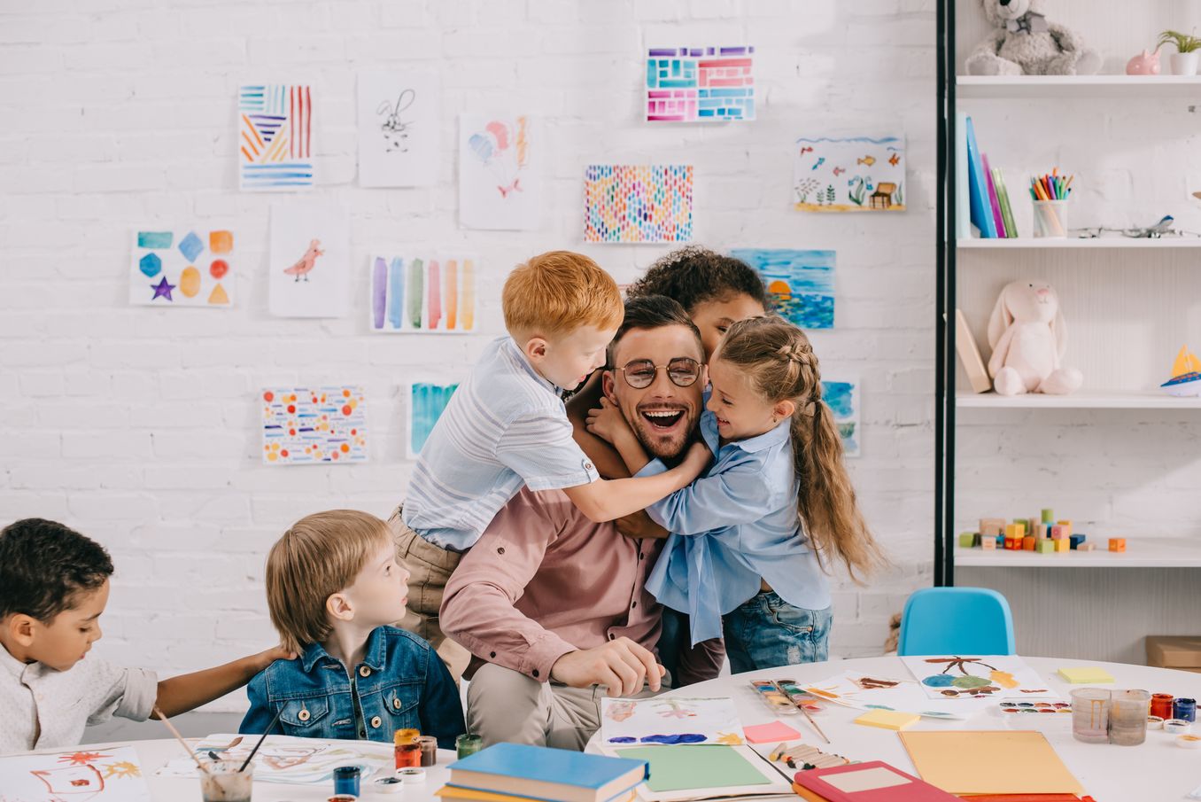 Sozialpädagogik Studium – Erzieher wird von Kindern umarmt