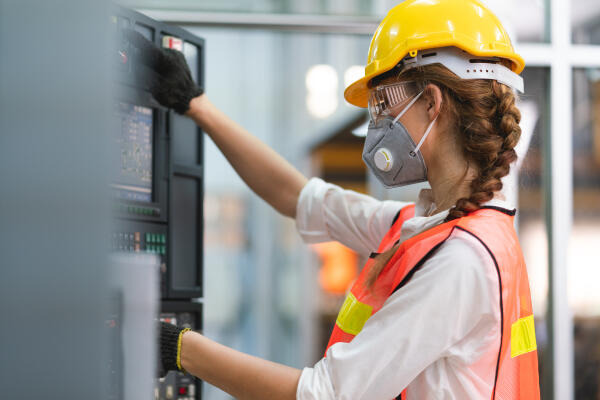 Elektrotechnikermeisterin wartet CNC-Maschine Elektrotechnikermeisterin wartet CNC-Maschine