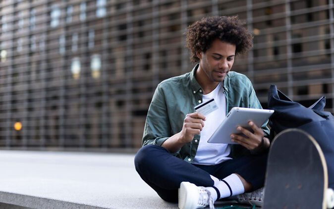 Internationaler Studentenausweis – Junger Mann mit ISIC und Tablet Internationaler Studentenausweis – Junger Mann mit ISIC und Tablet