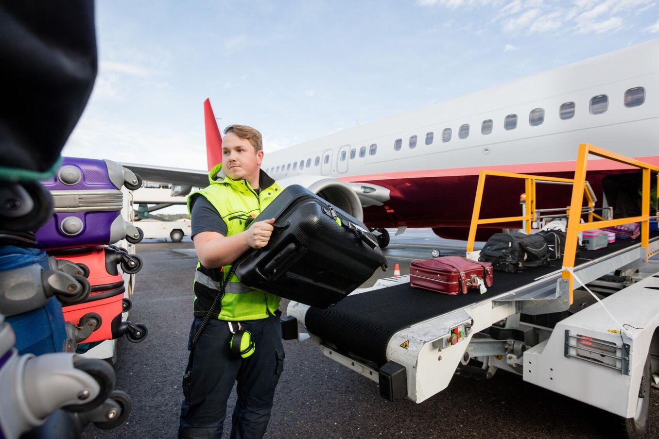 Ramp Agent verlädt Koffer