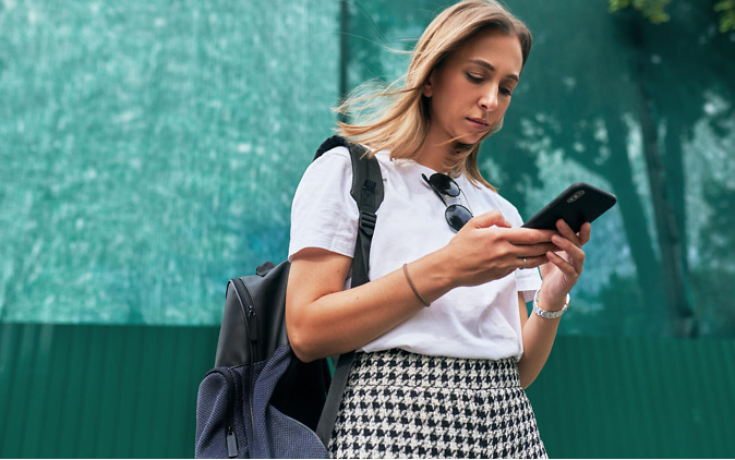 Arbeitslos nach Studium – junge Frau schaut nachdenklich auf Smartphone Arbeitslos nach Studium – junge Frau schaut nachdenklich auf Smartphone