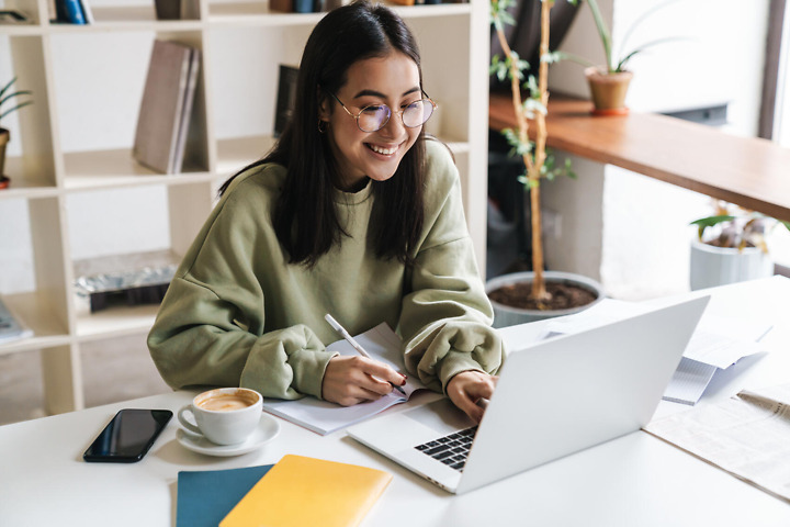 Studentin formatiert Bachelorarbeit Layout am Laptop