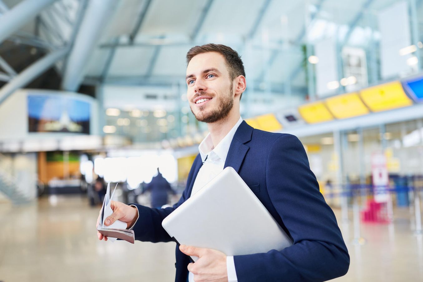 Arbeiten im Ausland – Mann am Flughafen mit seinen Reisedokumenten