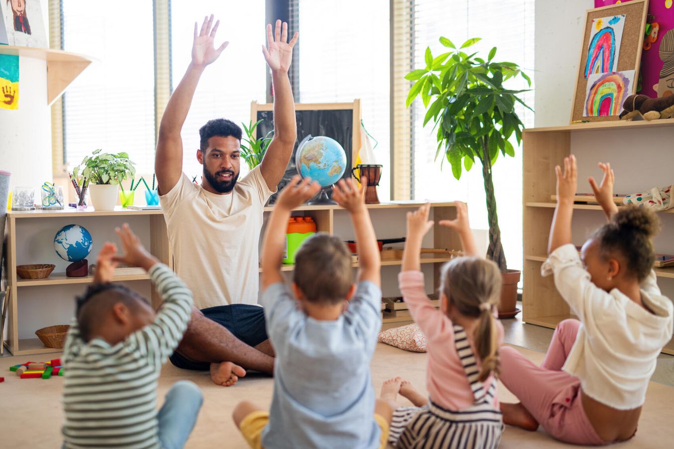 Kinderpfleger spielt mit Kindern