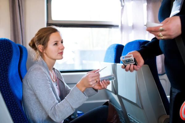 Zugbegleiter kontrolliert Fahrscheine