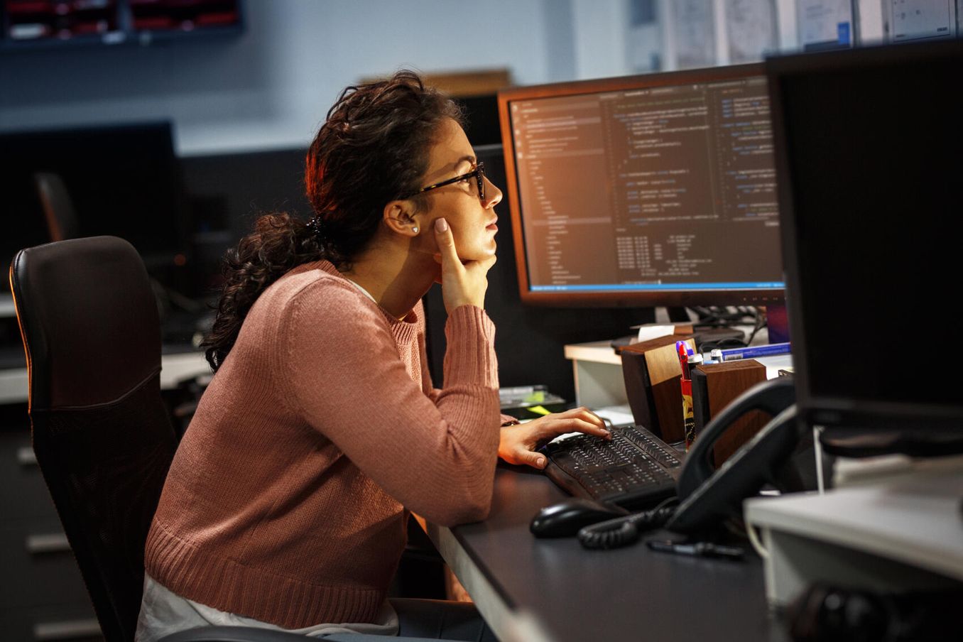 Junge Frau im Informatik Studium sitzt nachdenklich vor PC