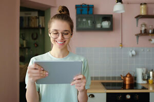 Junge Frau schreibt Studentenwohnung Bewerbung am Tablet Junge Frau schreibt Studentenwohnung Bewerbung am Tablet