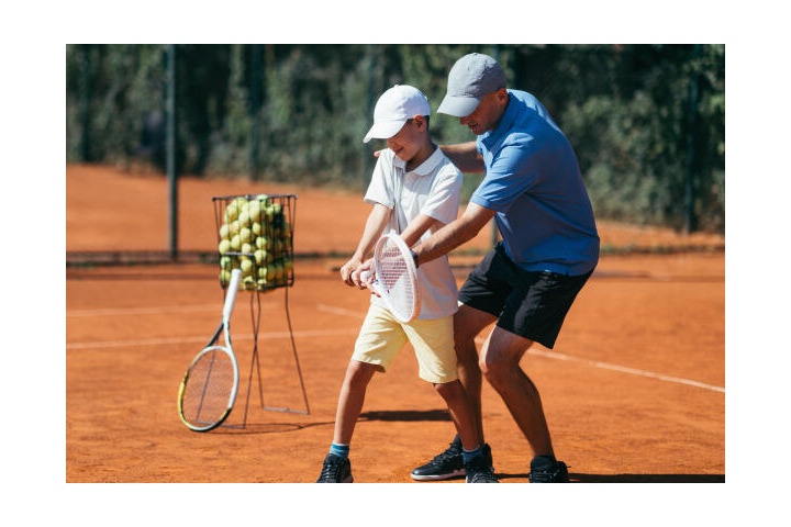 Tennislehrer mit Schüler