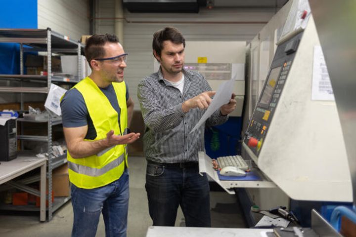 Werkzeugmechaniker erklärt Fertigungsmaschine.jpg