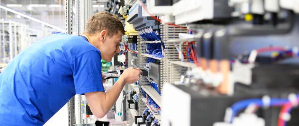 Elektroniker fuer Informations- und Systemtechnik analysiert Anlage