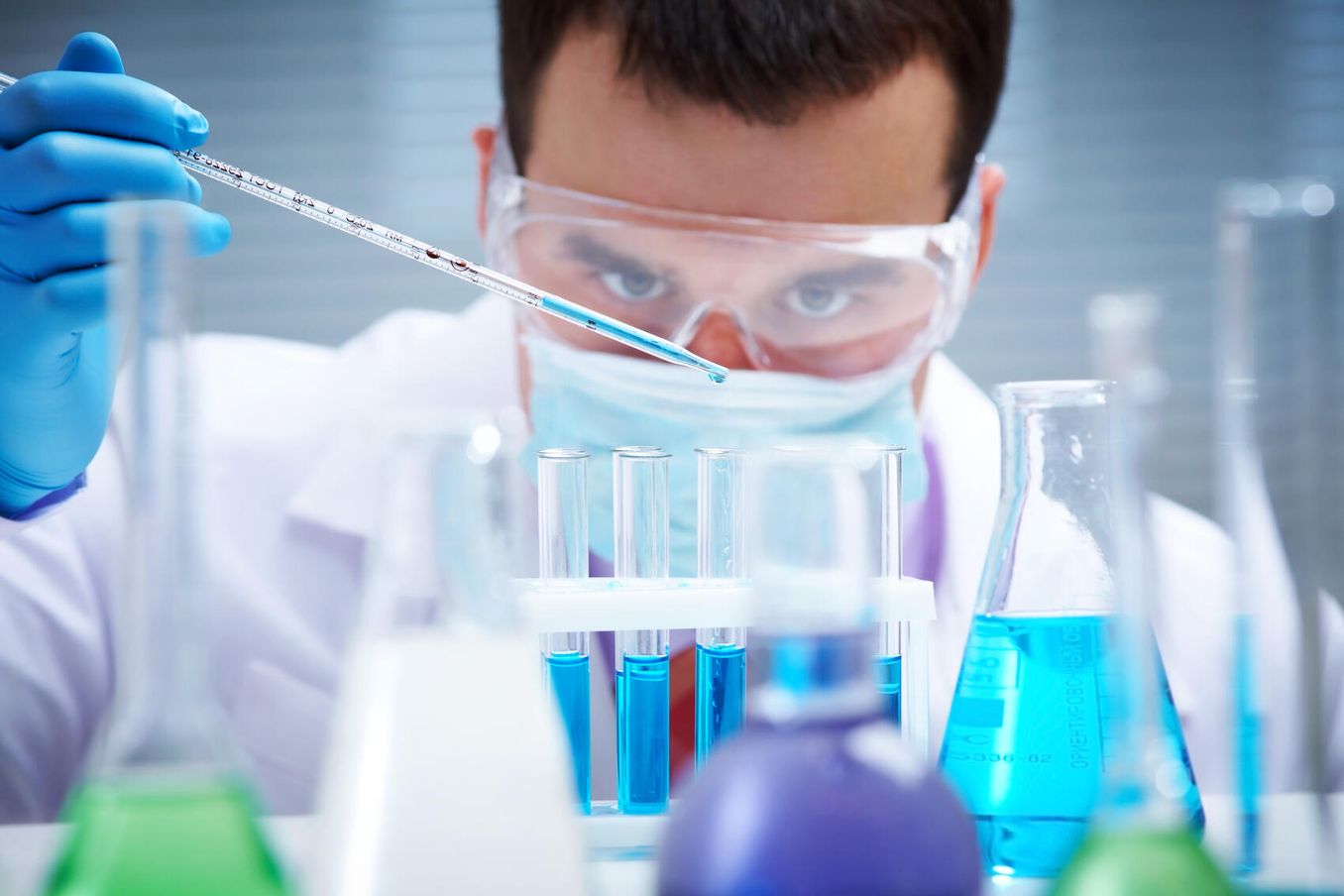 Ungewoehnliche Berufe – Mann mit Pipette und Reagenzglaesern