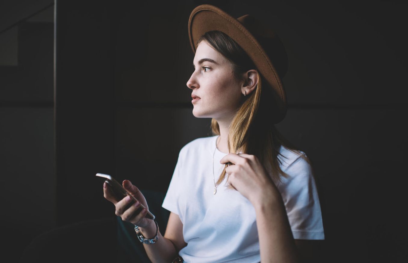 Maedchen liest haeufige Fragen am Smartphone