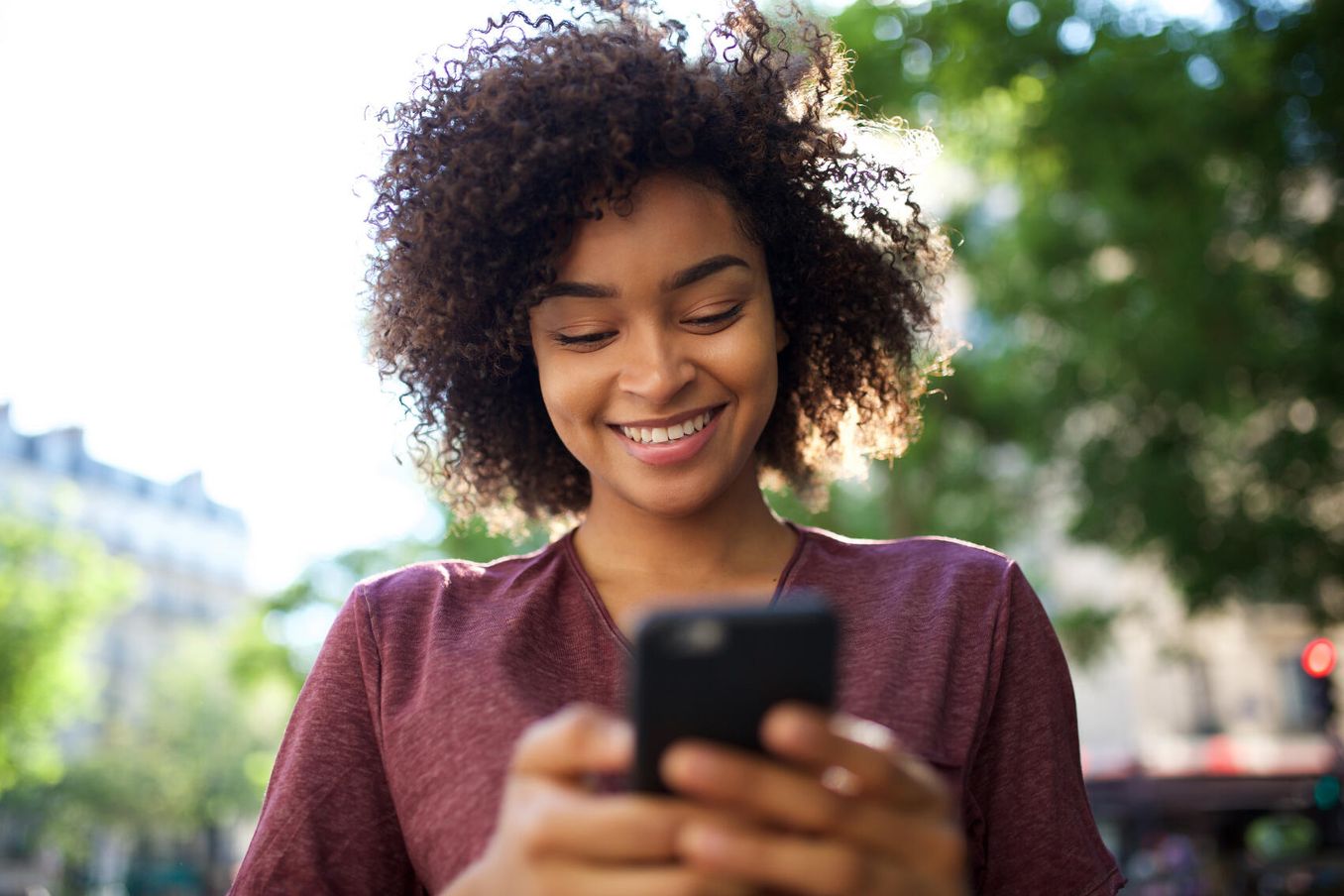 Frau im Freien benutzt Azubi-App am Handy
