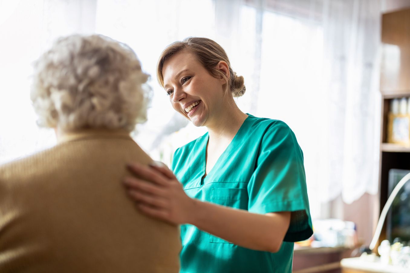 Pflegekraft spricht mit Patientin