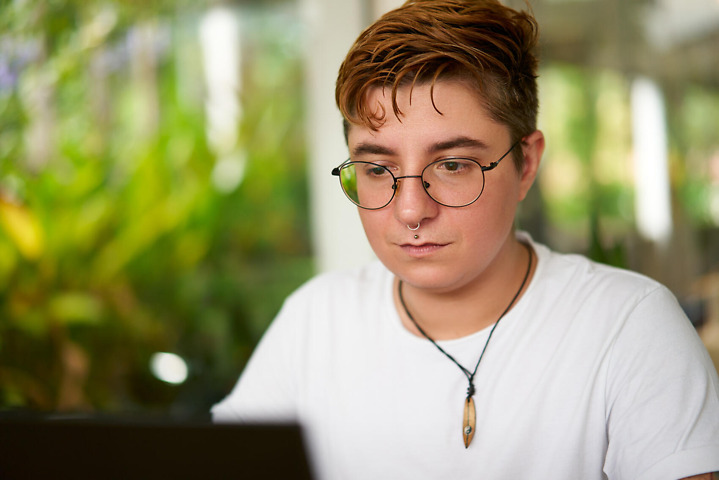 Person arbeitet fokussiert vor Bachelorarbeit Abgabe