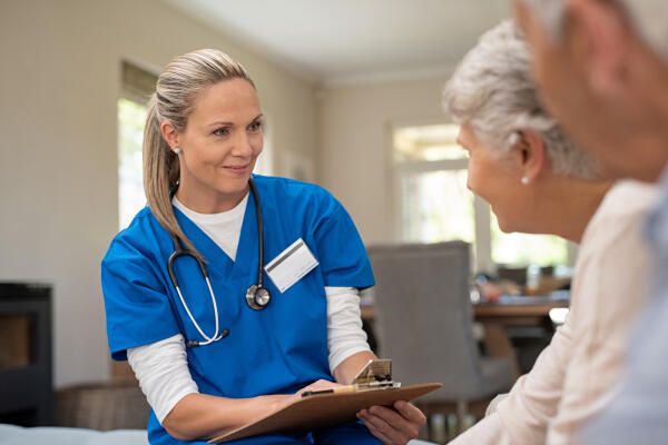 Krankenpflegerin spricht mit Patienten.jpeg