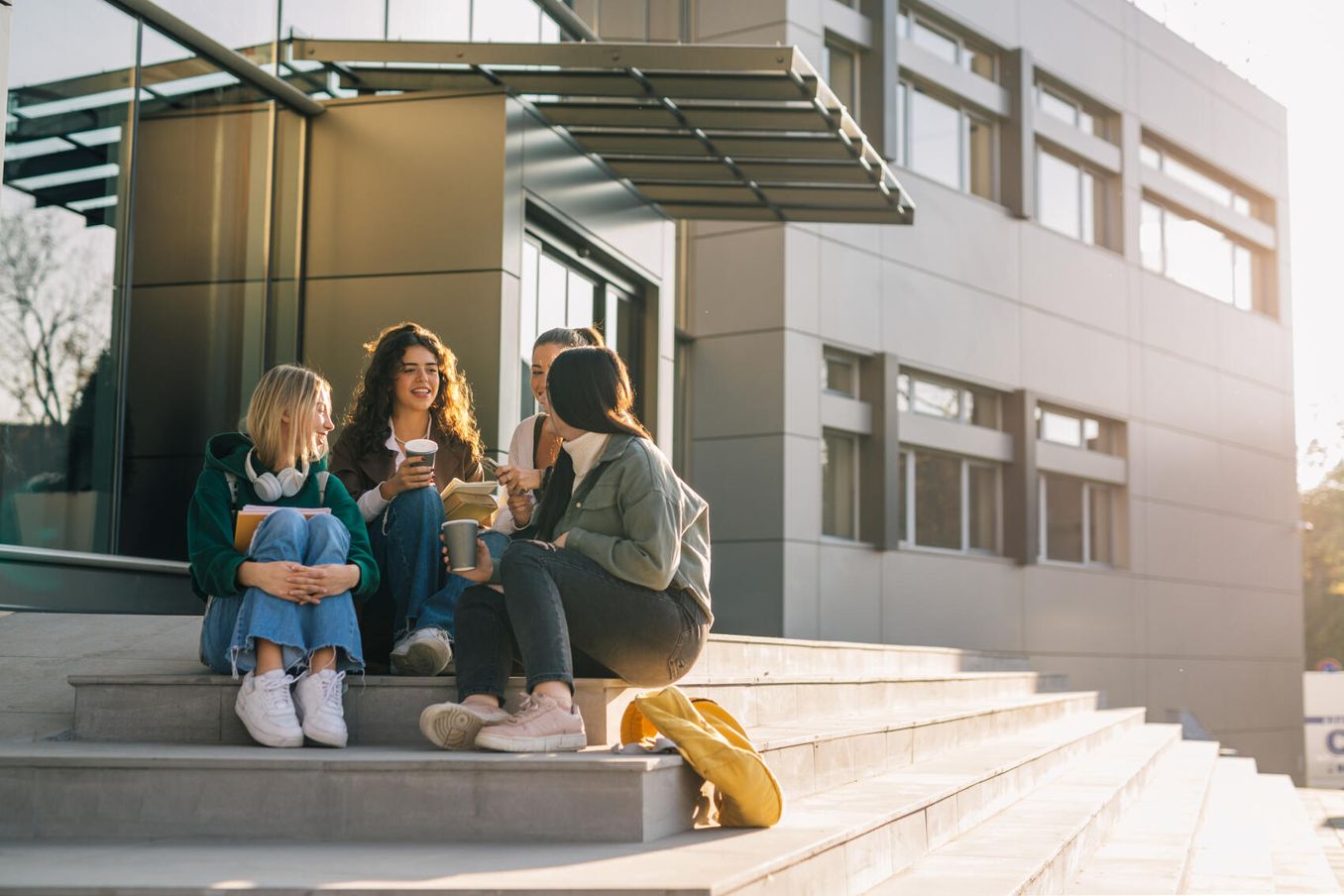 Studierende auf einer Treppe koennen sich ihr Studentenleben selbst finanzieren