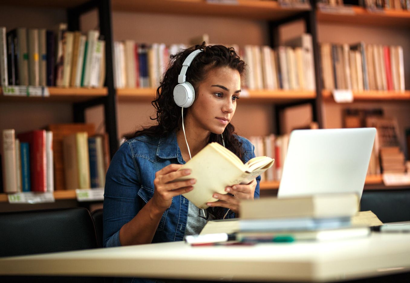 Masterarbeit schreiben – Studentin schreibt an ihrer Masterarbeit in der Bibliothek
