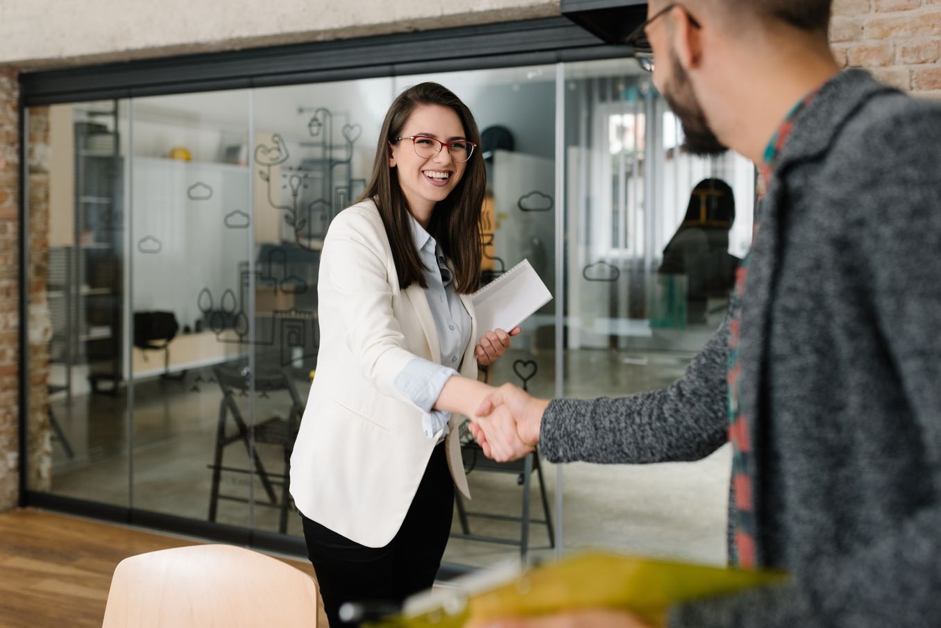 Recruiterin begruesst einen Bewerber