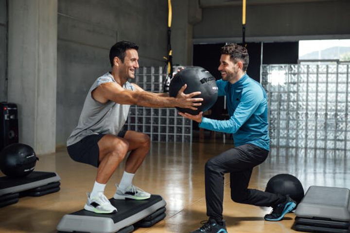 Personal Trainer unterstützt bei Übung