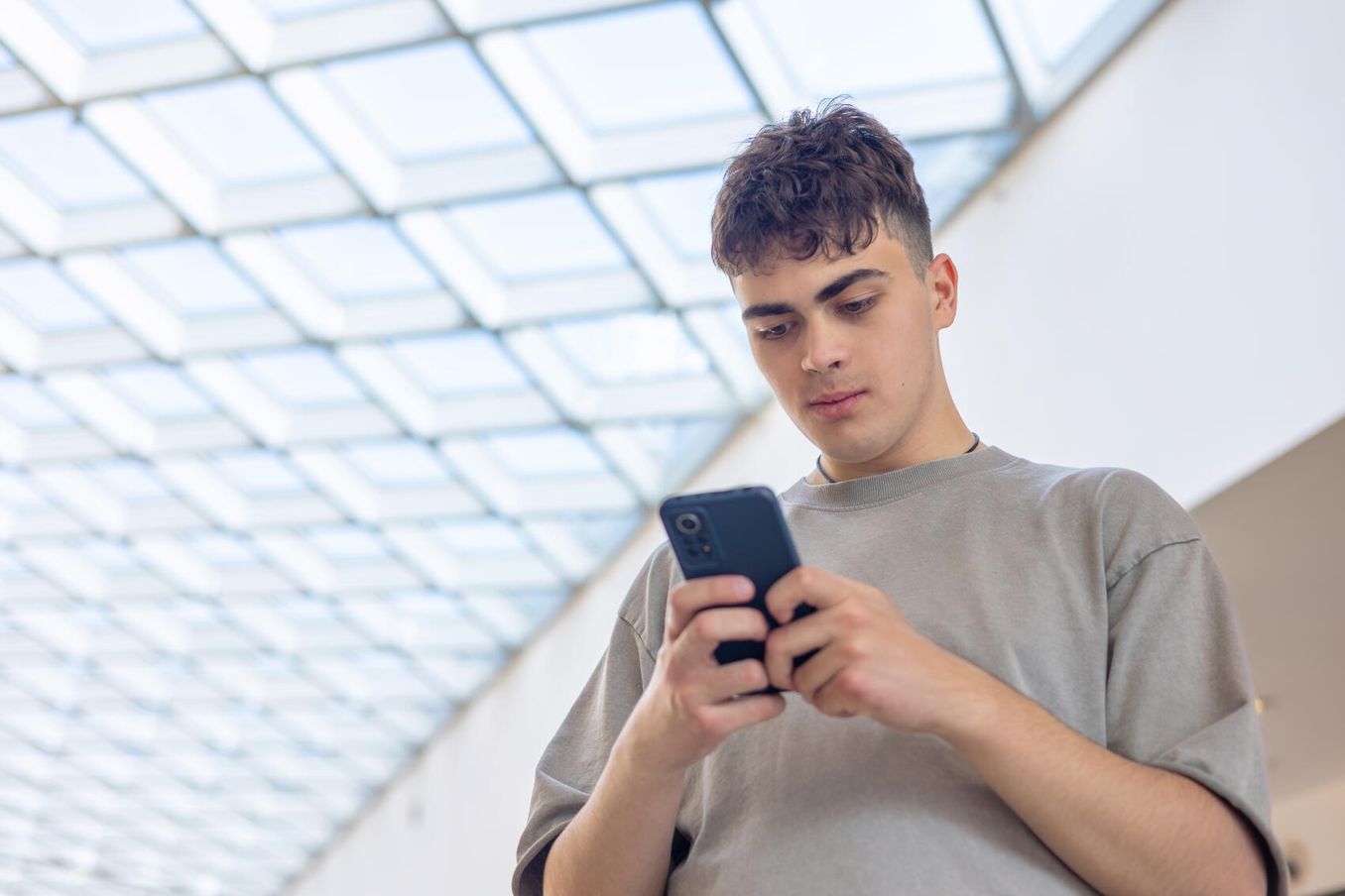 Junger Mann richtet WhatsApp-Stellenalarm auf seinem Smartphone ein