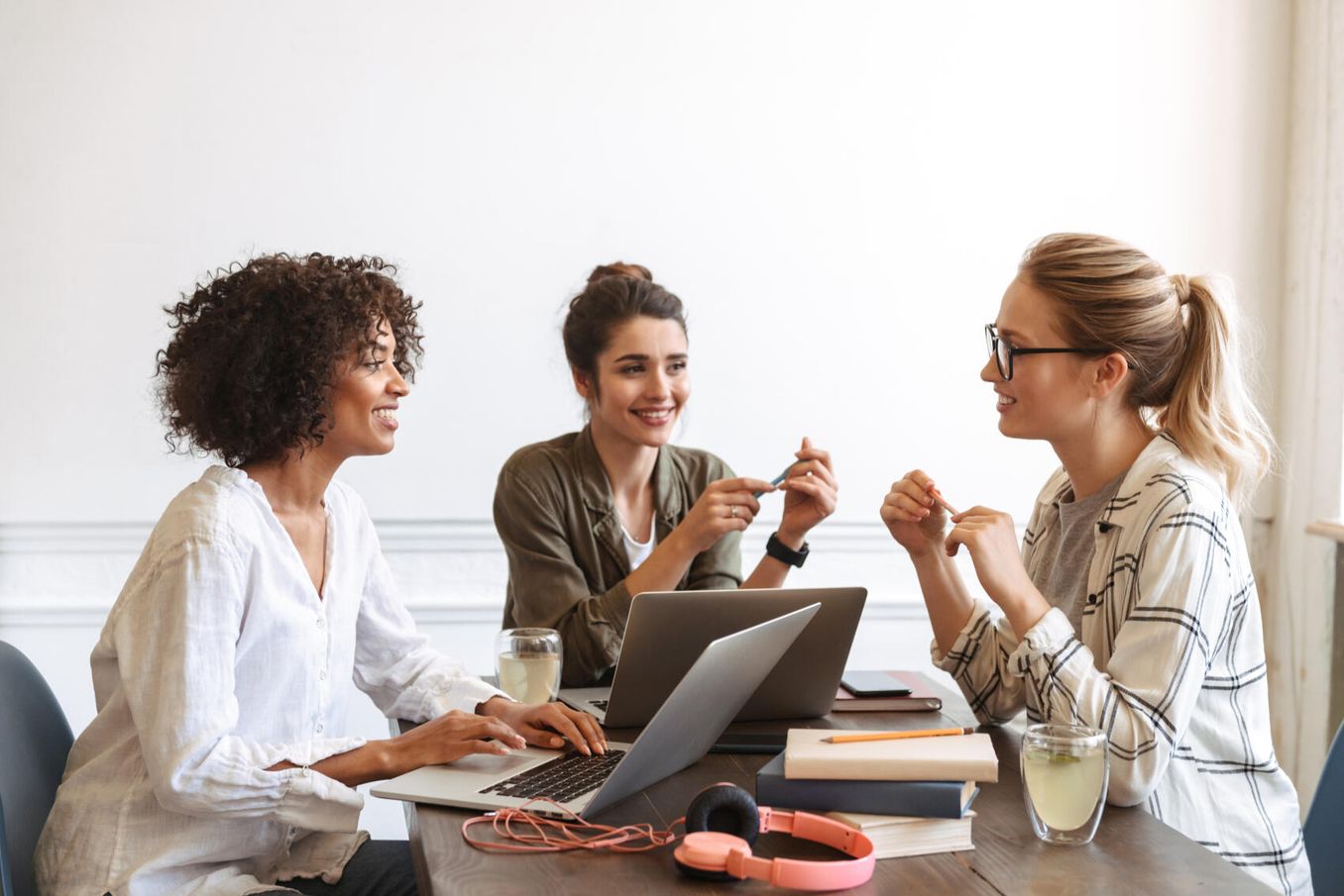 Arbeitsbedingungen – 3 Frauen in Buero unterhalten sich