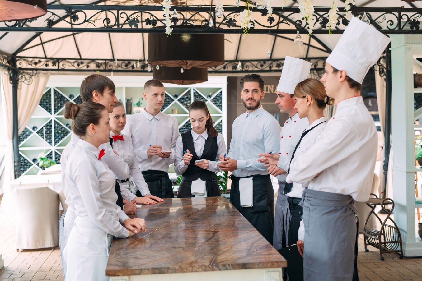 Fachkraft für Gastronomie – Mitarbeitende tragen bei einer Besprechung einheitliche Kleidung