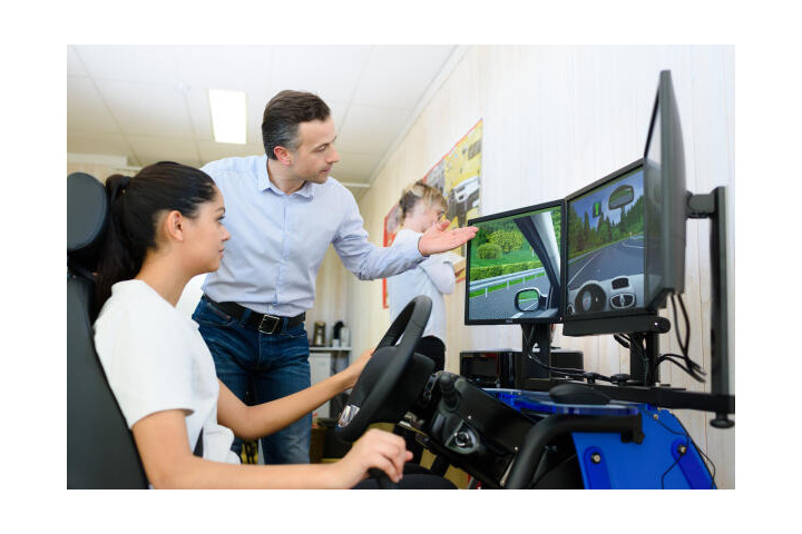 Fahrlehrer erklärt erste Grundschritte mit Simulator