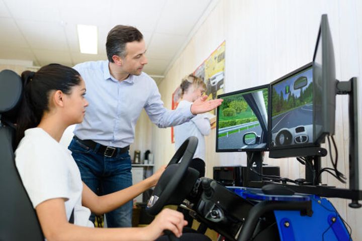 Fahrlehrer erklärt erste Grundschritte mit Simulator
