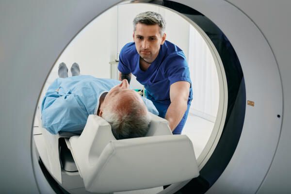 Student im Radiologie Studium schiebt Patienten in CT