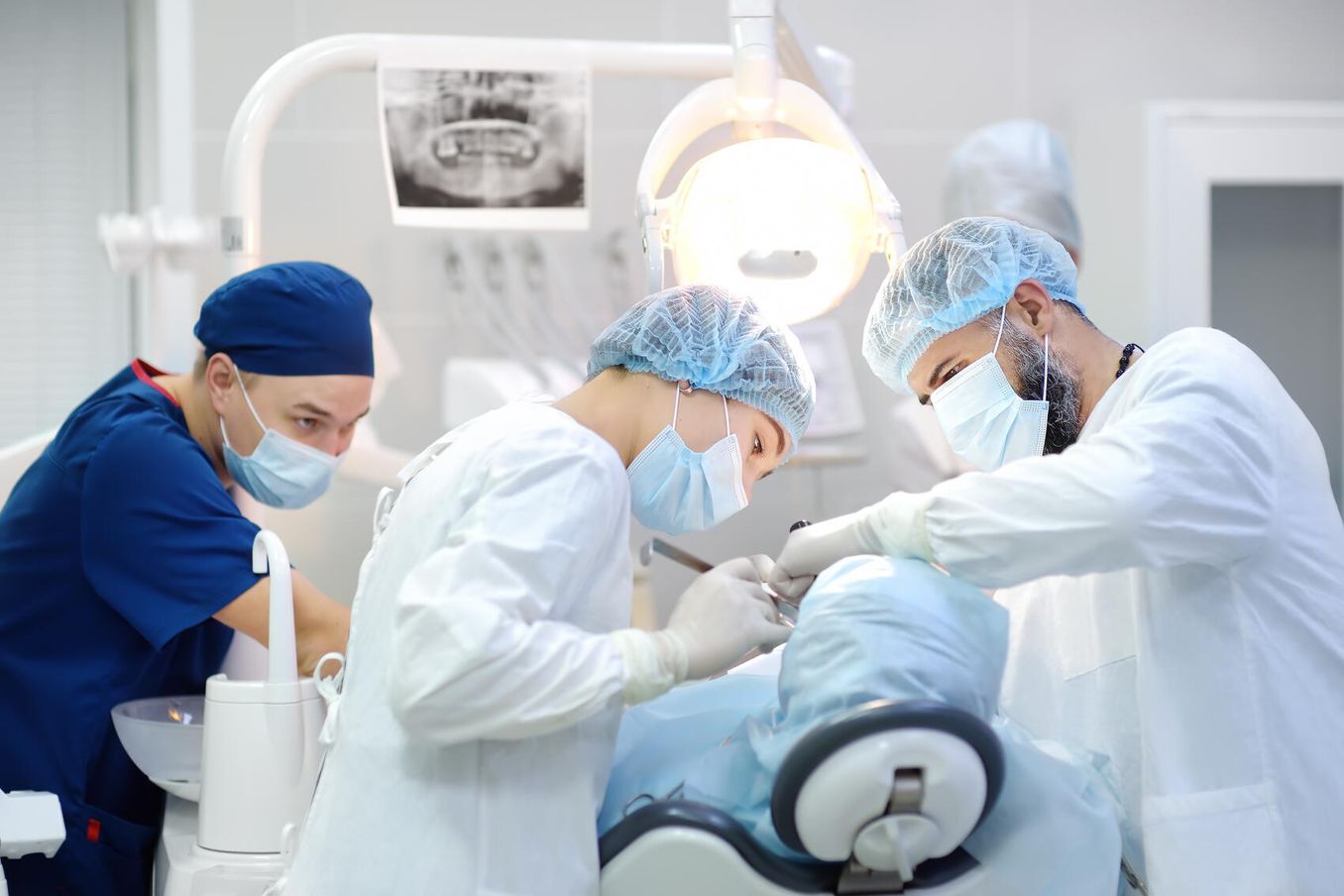 Zahnarzt und Zahnaerztin behandeln Patienten