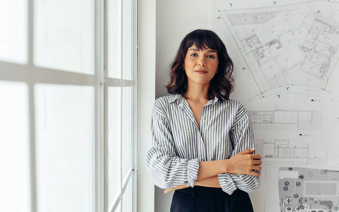 Selbstwirksamkeit Selbstwirksamkeit – Junge Frau steht selbstbewusst an Wand