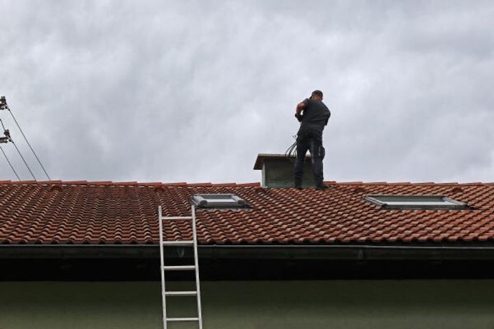 Schornsteinfeger arbeiten auf Dächern