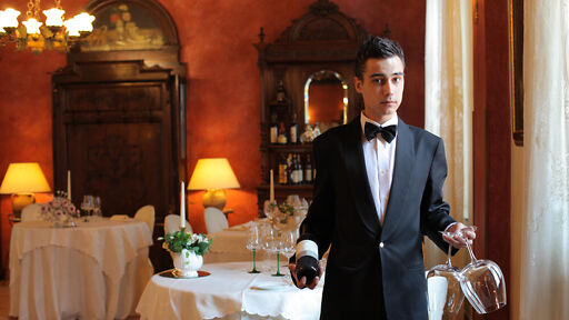 Fachkraft für Gastronomie – Mann serviert Rotwein Fachkraft für Gastronomie – Mann serviert Rotwein
