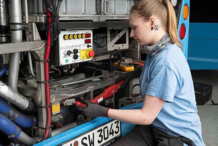 WSW Wuppertaler Stadtwerke GmbH: Kraftfahrzeugmechatronikerin arbeitet am Wasserstoffbus