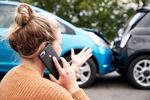 Frau telefoniert nach Autounfall
