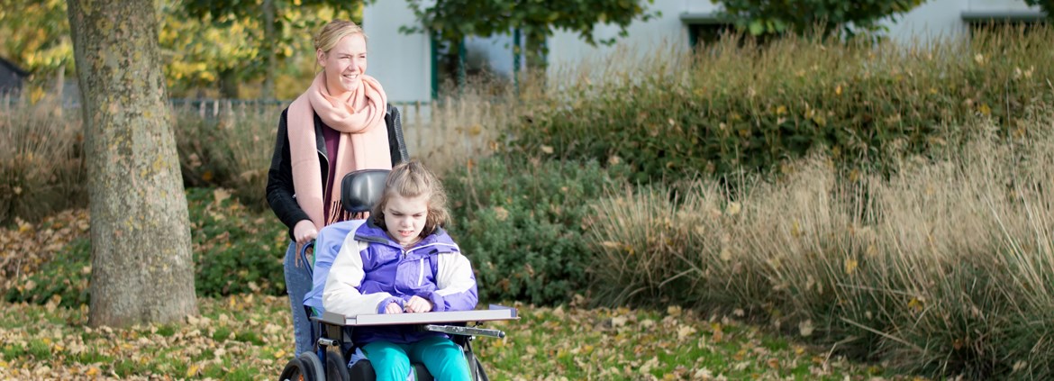 Schulbegleiterin mit Schülerin im Rollstuhl