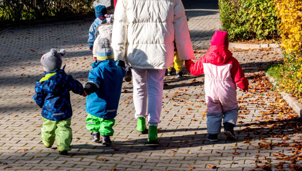 Kindergärtnerin mit Kindern beim Spaziergang
