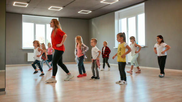 Sportlehrerin bringt Kindern einen Tanz bei