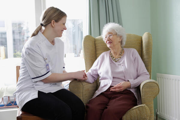 Pflegerin spricht mit alter Frau